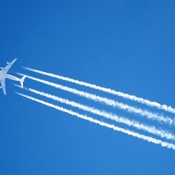 an image of a jet streaking across the sky, with contrails being left behind